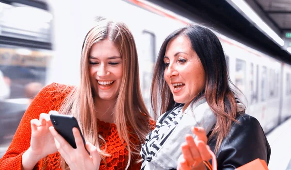 Casal Amigas Olhando Para Telefone Uma Estação Metrô Com Trem — Fotografia de Stock