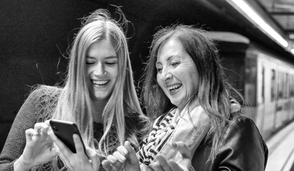 Par Amigas Sonriendo Felices Mirando Smartphone Una Estación Metro — Foto de Stock