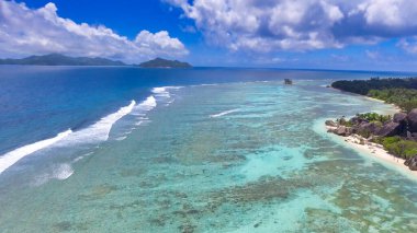 Drone 'dan Mercan Kayalıkları' na. Güneşli bir günde Seyşeller plajı ve kayalar.