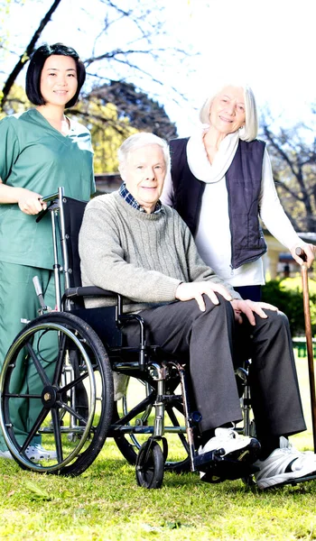 Personnes Âgées Avec Fauteuil Roulant Assistées Par Une Infirmière Extérieure — Photo