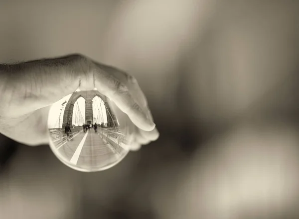 Mão Masculina Segurando Uma Bola Transparente Com Reflexos Brooklyn Bridge — Fotografia de Stock