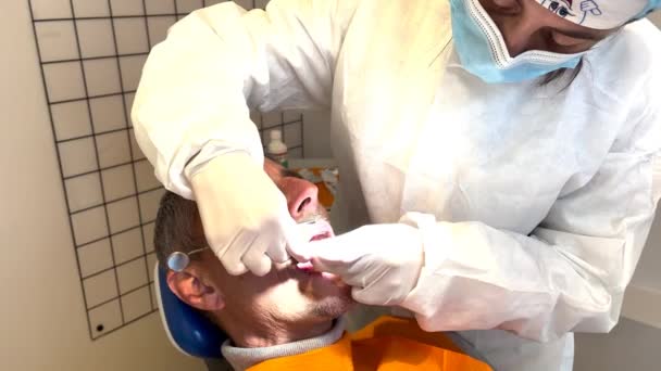 치과에서 치아를 닦고 있는 남자 — 비디오
