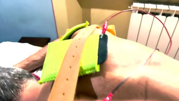 Spierstimulator met elektroden aangebracht op biceps en schouders door een professionele fysiotherapeut — Stockvideo