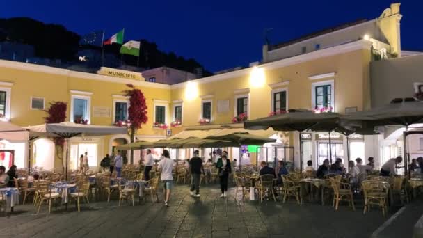 CAPRI, ITÁLIE - 19. června 2021: Turisté a místní obyvatelé při západu slunce obcházejí slavnou Piazzettu — Stock video