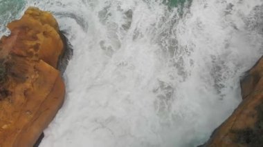 Kıyı şeridi kayalara çarpan dalgalarla, yukarıdan bakıldığında....