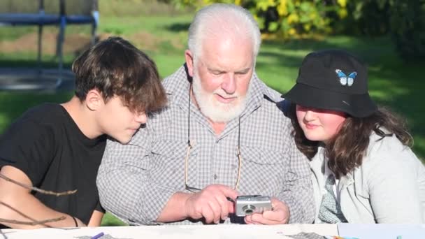 Man Reviewing Camera Pictures Outdoor His Grandchildren — Stock Video