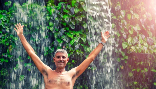 Szczęśliwy Człowiek Obejmujący Naturę Pod Pięknym Wodospadem — Zdjęcie stockowe