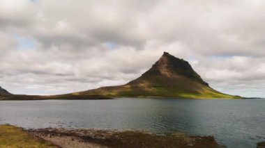 Arkasında göl ve okyanus olan ünlü İzlanda dağı Kirkjufell. Kirkjufell Dağı, yaz mevsiminde Snaefellsnes Yarımadası 'nda İHA bakış açısıyla.