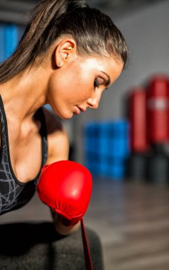 Kırmızı eldiven ile spor salonunda eğitim kadın tekme boksör.