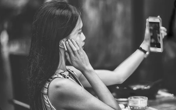 アジアのビジネス女性はイヤフォンを屋外でスマートフォンに話している — ストック写真