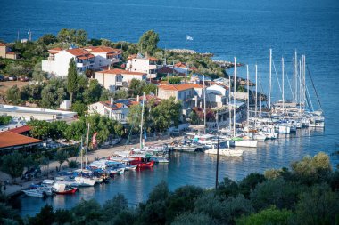 Alonissos, Yunanistan - 5 Temmuz 2022: Steni Vala limanı ve evleri hava günbatımı manzarası.