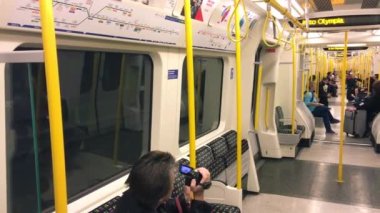 LONDON, İngiltere - 26 Eylül 2016: Bir yeraltı metro treninde turistler ve yerel halk.