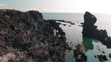 Reynisdrangar 'ın ünlü kaya oluşumları. Siyah Reynisfjara Sahili' nde. Yaz mevsiminde İHA 'dan dolayı Güney İzlanda, Vik yakınlarında Atlantik Okyanusu kıyısında..