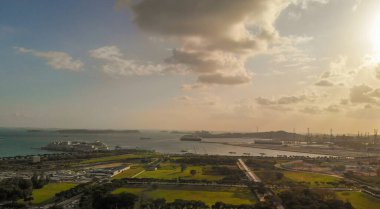 Singapur 'daki Marina Körfezi bölgesinde. Güneşli bir günde şehrin kenar mahallelerinin havadan görünüşü