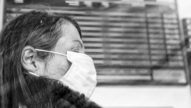 Coronavirus zamanlarında havaalanındaki kadın reklam panosunun önünde..