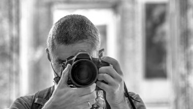 Male photographer taking pictures of a museum interior with a professional camera.