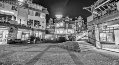 Whistler, Kanada - 11 Ağustos 2017: Turistler gün batımında şehir merkezini ziyaret ederler. Whistler ünlü bir turistik dağ beldesidir.