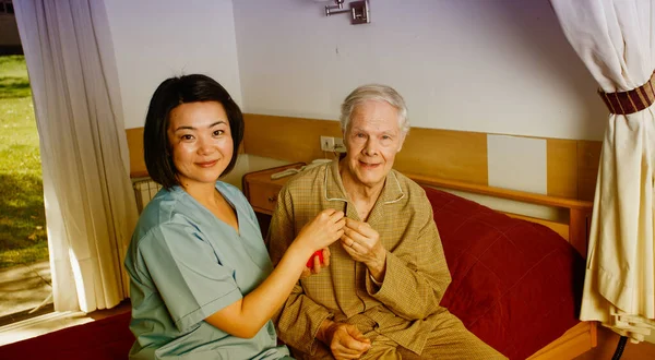 Aziatische Verpleegkundige Medische Pil Overhandigen Aan Oudere Mens Ziekenhuisbed — Stockfoto