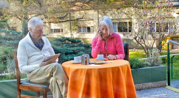 Casal Aposentado Caucasiano Usando Gadgets Tecnológicos Relaxando Jardim Para Café — Fotografia de Stock