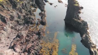 Reynisdrangar 'ın ünlü kaya oluşumları. Siyah Reynisfjara Sahili' nde. Yaz mevsiminde İHA 'dan dolayı Güney İzlanda, Vik yakınlarında Atlantik Okyanusu kıyısında..