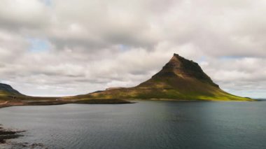 Arkasında göl ve okyanus olan ünlü İzlanda dağı Kirkjufell. Kirkjufell Dağı, yaz mevsiminde Snaefellsnes Yarımadası 'nda İHA bakış açısıyla.