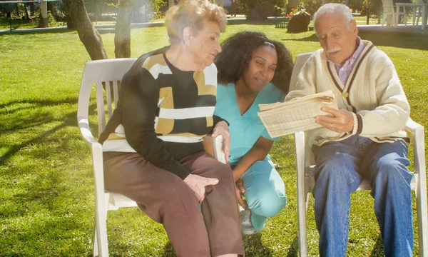African Nurse Using Tablet Elderly Retired Couple Outdoor Rehab Hospital — Stockfoto