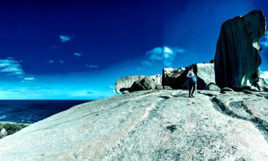 Woman and daughter visit Remarkable Rocks in Kangaroo Island, panoramic view.
