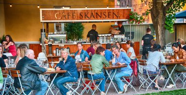 OSLO - 5 Haziran 2010: Turistler Oslo 'da güneşli bir günde şehrin sokaklarının keyfini çıkarıyorlar. Şehri her yıl 3 milyondan fazla insan ziyaret ediyor..