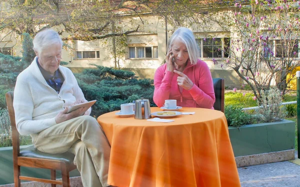 Casal Aposentado Caucasiano Usando Gadgets Tecnológicos Relaxando Jardim Para Café — Fotografia de Stock