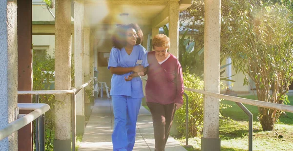 Afrikanische Ärztin Gespräch Mit Einer Älteren Rentnerin Auf Dem Hof — Stockfoto
