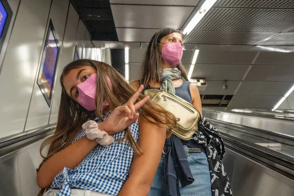 Fiatal Lány Anyjával Metró Mozgólépcsőjén Mindketten Rózsaszín Maszkot Viselnek — Stock Fotó