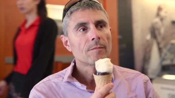 Человек Ест Мороженое Посещая Город — стоковое видео