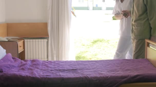 Pomoc Starszemu Mężczyźnie Położeniu Się Łóżka Szpitalu — Wideo stockowe