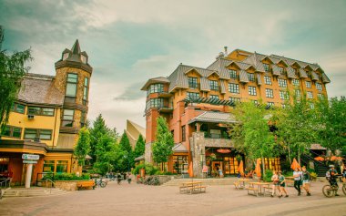 Whistler, Kanada - 12 Ağustos 2017: Güneşli bir günde şehir merkezini ziyaret eden turistler. Whistler ünlü bir turistik dağ beldesidir.