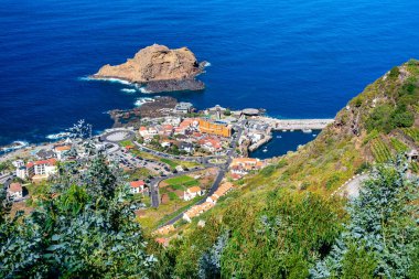 Porto Moniz doğal lav havuzları ve gün batımında Madeira dağları, Portekiz.