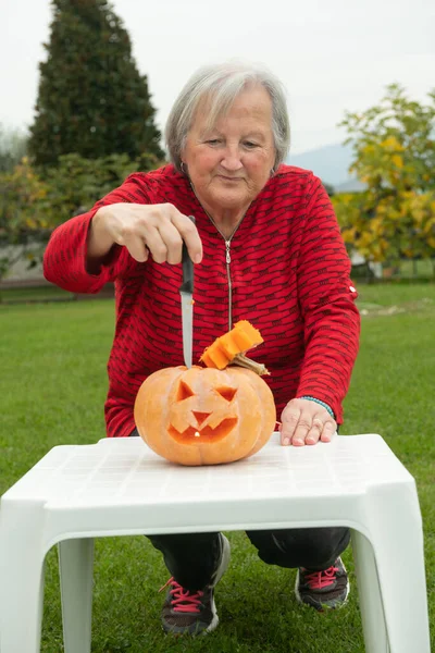 Donna Anziana Che Taglia Una Grande Zucca Halloween — Foto Stock