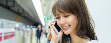 Akıllı telefon kullanan Asyalı bir kız. İş ve eğlence kavramı.