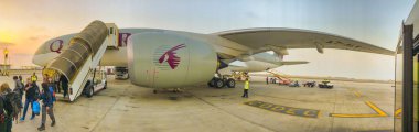 Doha, Katar - 17 Eylül 2018: Katar Havayolları uçağı gün doğumunda pistte, panoramik manzara.