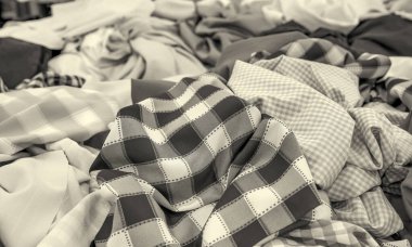 Kumaş dokusuna yakın çekim. Farklı renklerde kumaş örnekleri seçim için istiflenir. Mobilya ve iç mekan için çeşitli tonlar ve malzemeler. Bir dizi renkli kumaş rulosu..