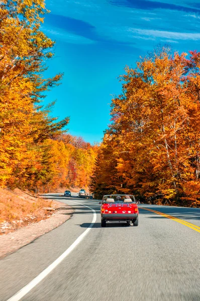 古いヴィンテージの赤い車は 米国の紅葉シーズンにニューイングランドの道に沿って運転します — ストック写真