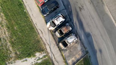 Burned cars in a city parking. Vandalism concept, aerial view drom drone