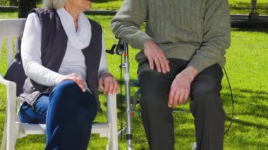 Bahçede konuşan bir çift yaşlı insan..