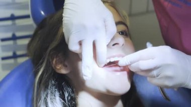Beyaz bir kız dişçide diş temizliği yaptırıyor..