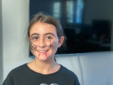 Cadılar Bayramı için giyinmiş ve gülümseyen genç bir kız..