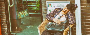 HONG KONG - 8 Mayıs 2014: 7-Eleven mağazasının önünde uyuyan yorgun işçi