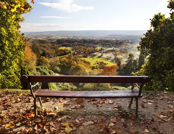 Bench in a park with views of the countryside. — Stock Photo, Image