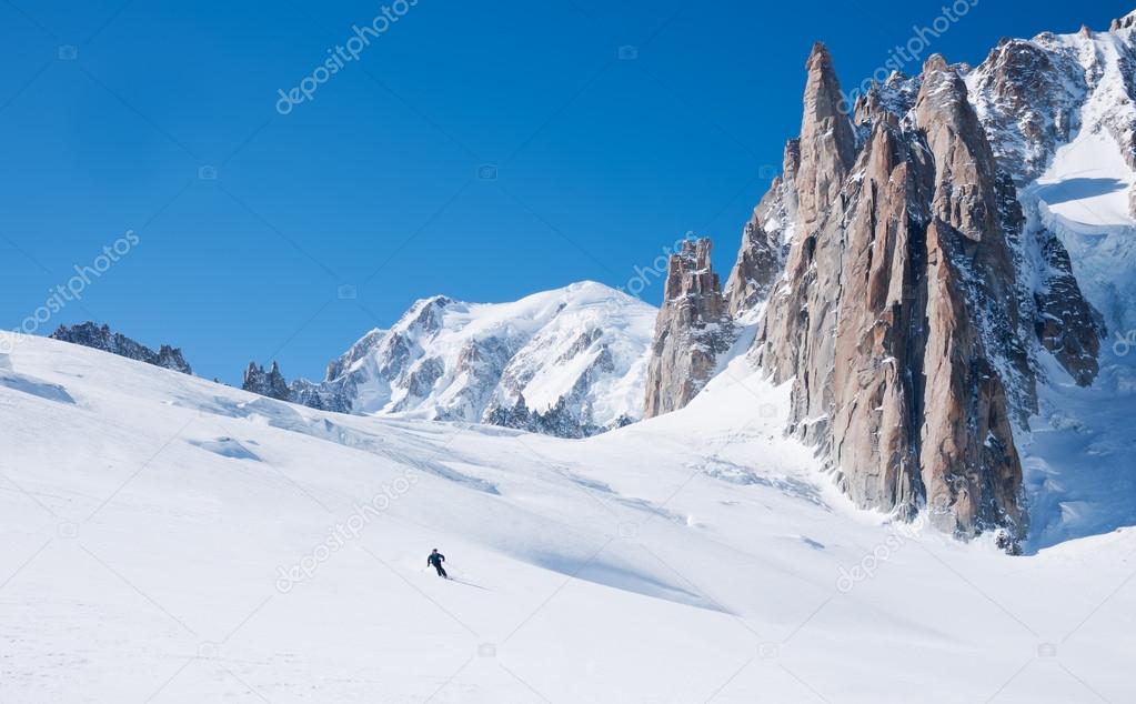 Skier goes downhill on a alpine glacier