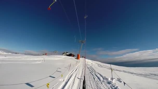 Skier goes uphill along a slope using a platter lift. — Stock Video