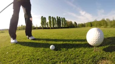 golfçü tee atış yapar..