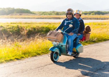 Piemonte, İtalya - 11 Mayıs 2010: bir köpek ile bir çift binmek bir vespa